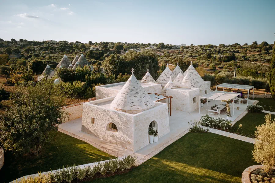 Traditional structures adapted for modern comfort: thick stone walls, shaded outdoor spaces and native landscaping