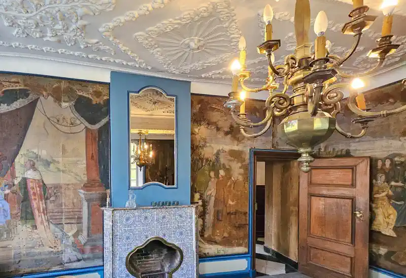 The historic wallpaper room in Château Thor, featuring wall paintings and original furnishings